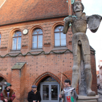 Stadtführer Arne Mahrzahn, Oberbürgermeister Klaus Schmotz und Andreas Meßing im Rolandkostüm begrüßen den Roland